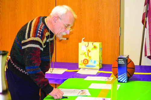 Bruce Rogers checks out items on the silent auction table. 