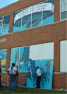 Scarritt Elementary School murals. KCPS officials helped Hector Casanova and his students from the Kansas City Art Institute install murals on boards covering windows on the closed elementary school. The installation of the murals completes phase one of the project. The next phase, with a new group of students, should begin within the next few weeks with a new set of ideas for ways to beautify the school. Joe Jarosz