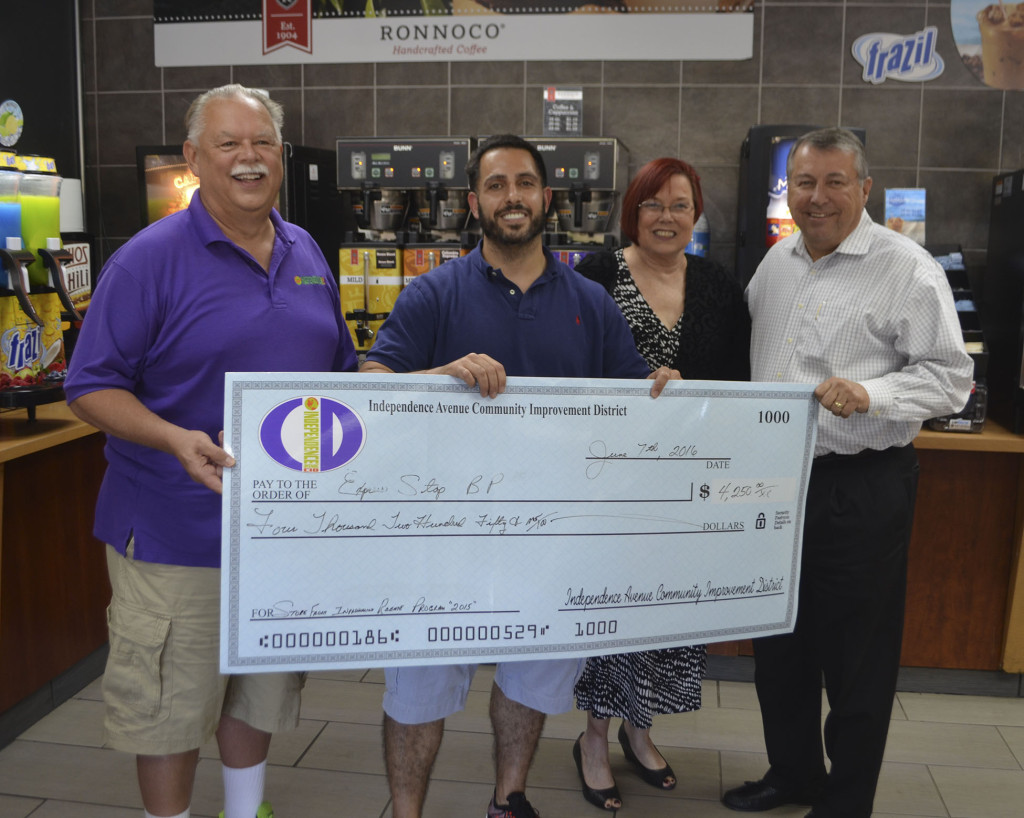 From left: CID member Carl Markus, BP Express Stop store manager Ziad Musallet, CID President Bobbi Baker-Hughes, and CID board member and President/CEO of Central Bank of Kansas City Bill Dana stand with a $4,250 rebate check Express Stop earned from the CID for improving its front facade.