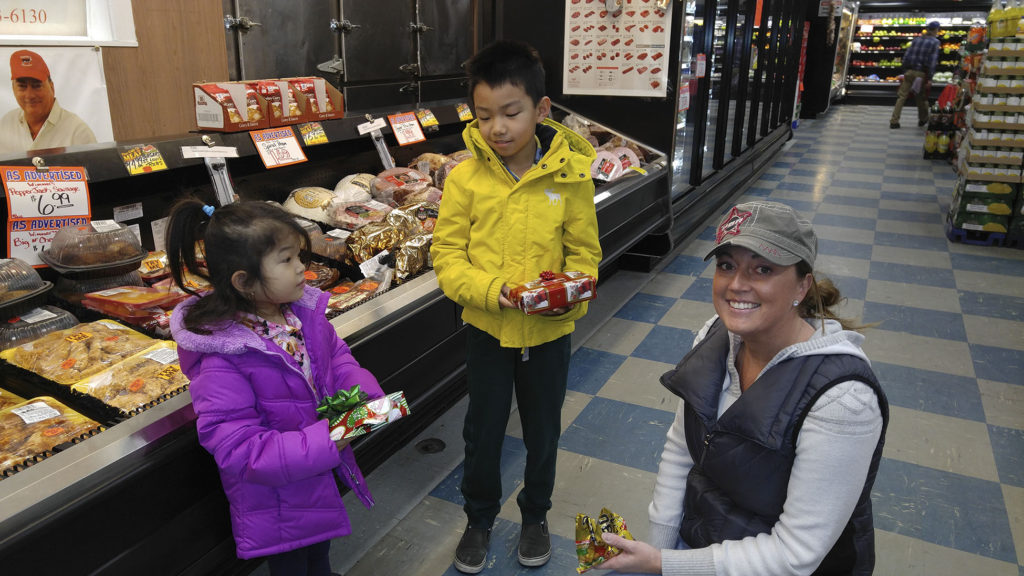 Snyder's General Manager Janelle James (right) hands out gifts to young customers on Thursday, December 22. 