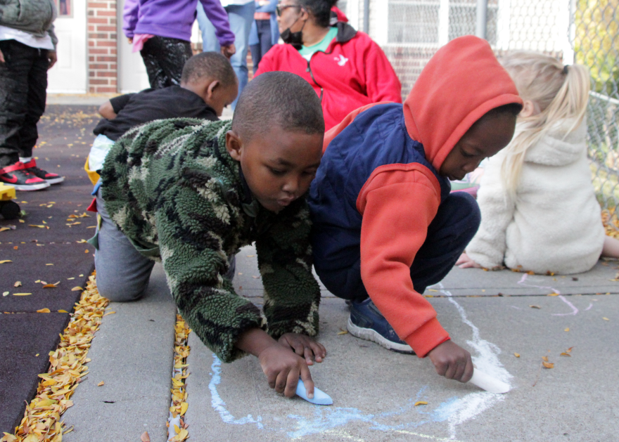 A group of kids play outside with chalk at the YMCA Head Start program in Kansas City’s Columbus Park neighborhood.