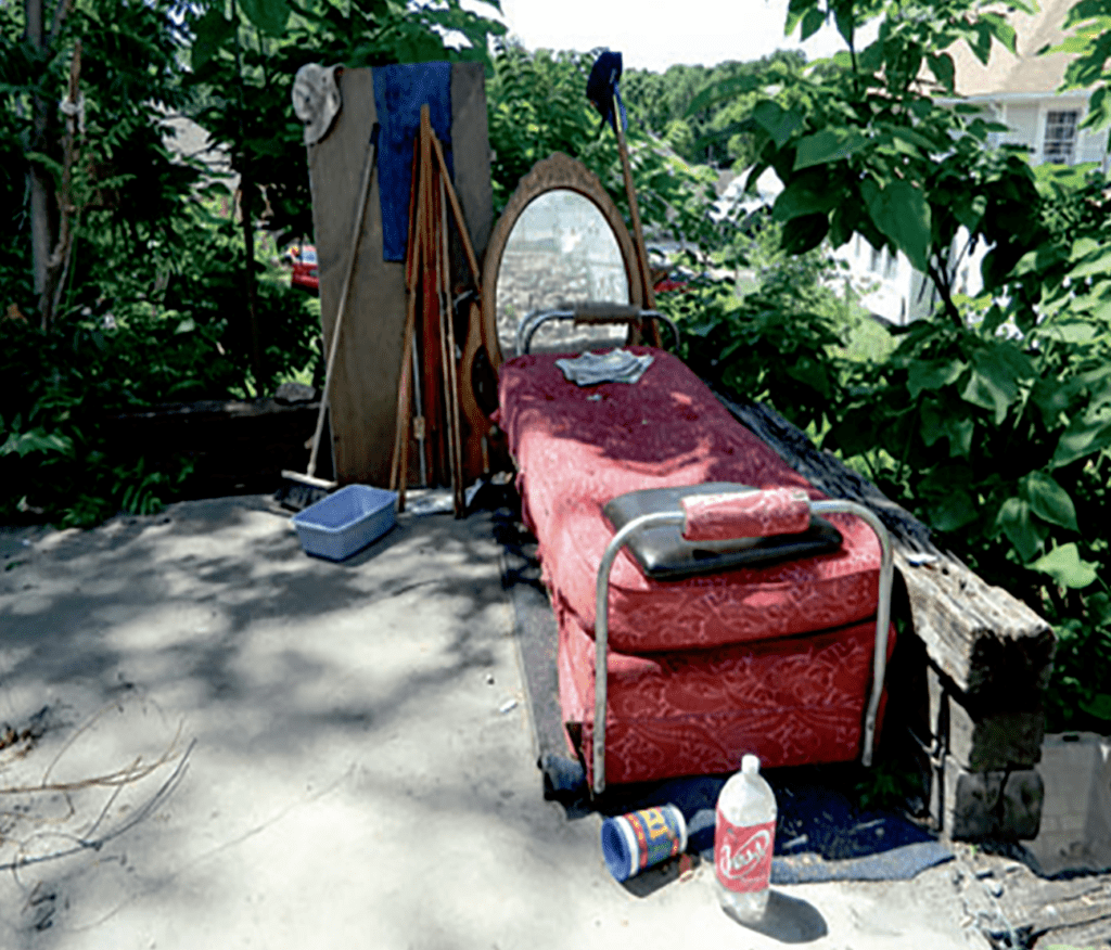 A make-shift bed and living space found in the middle of the woods