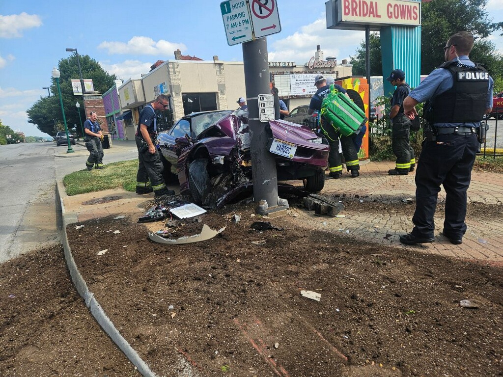 car crashes into traffic light post